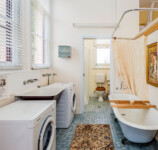 Restored bathroom with traditional clawed-foot bath and modern laundry facilities. Restored bathroom with traditional clawed-foot bath and modern laundry facilities.