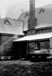 The old school bell stands outside the original entrance to the historic building. The old school bell stands outside the original entrance to the historic building.